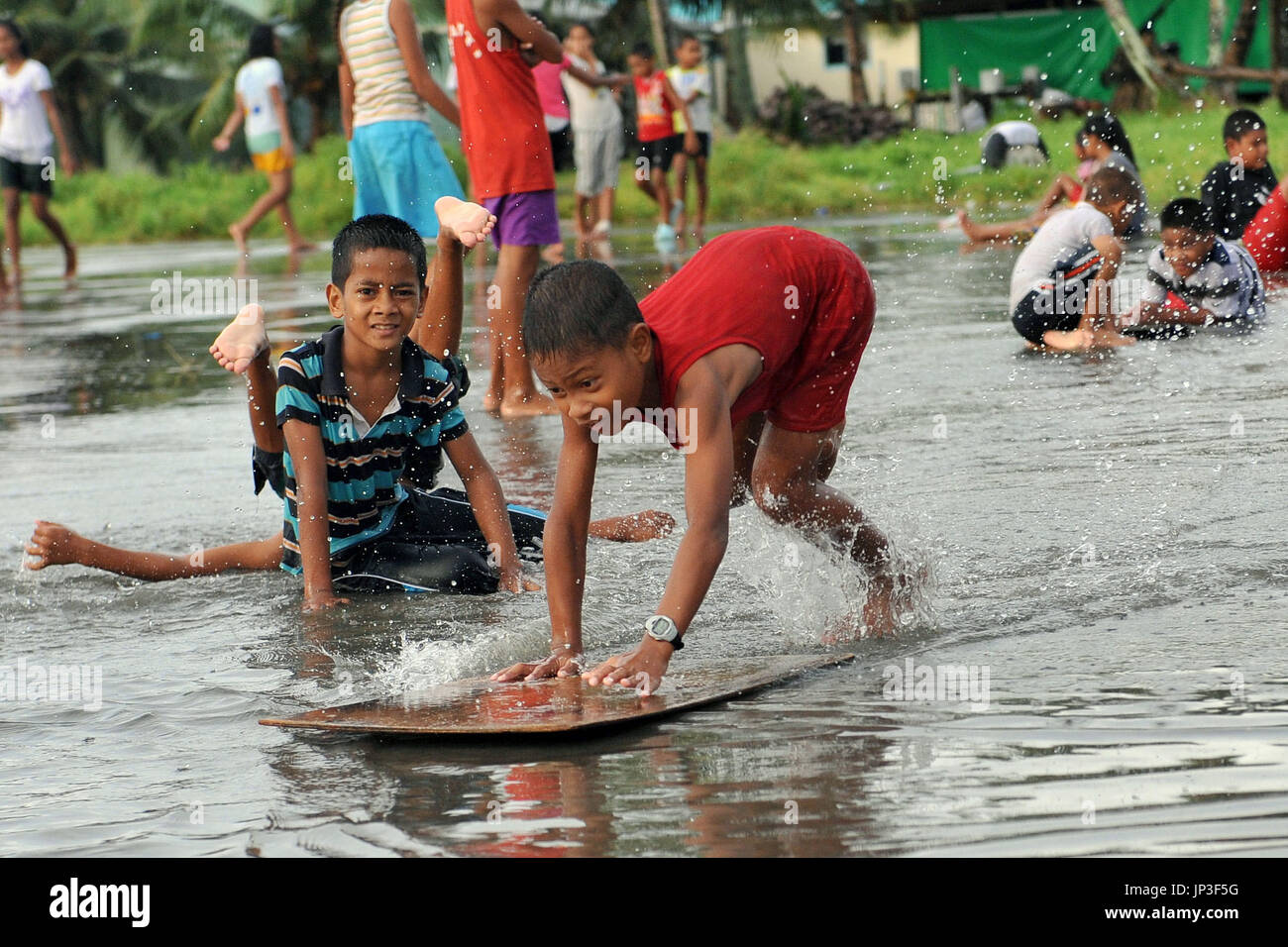 FUNAFUTI, Tuvalu - A boy "surfs" in a pool of water created on the
