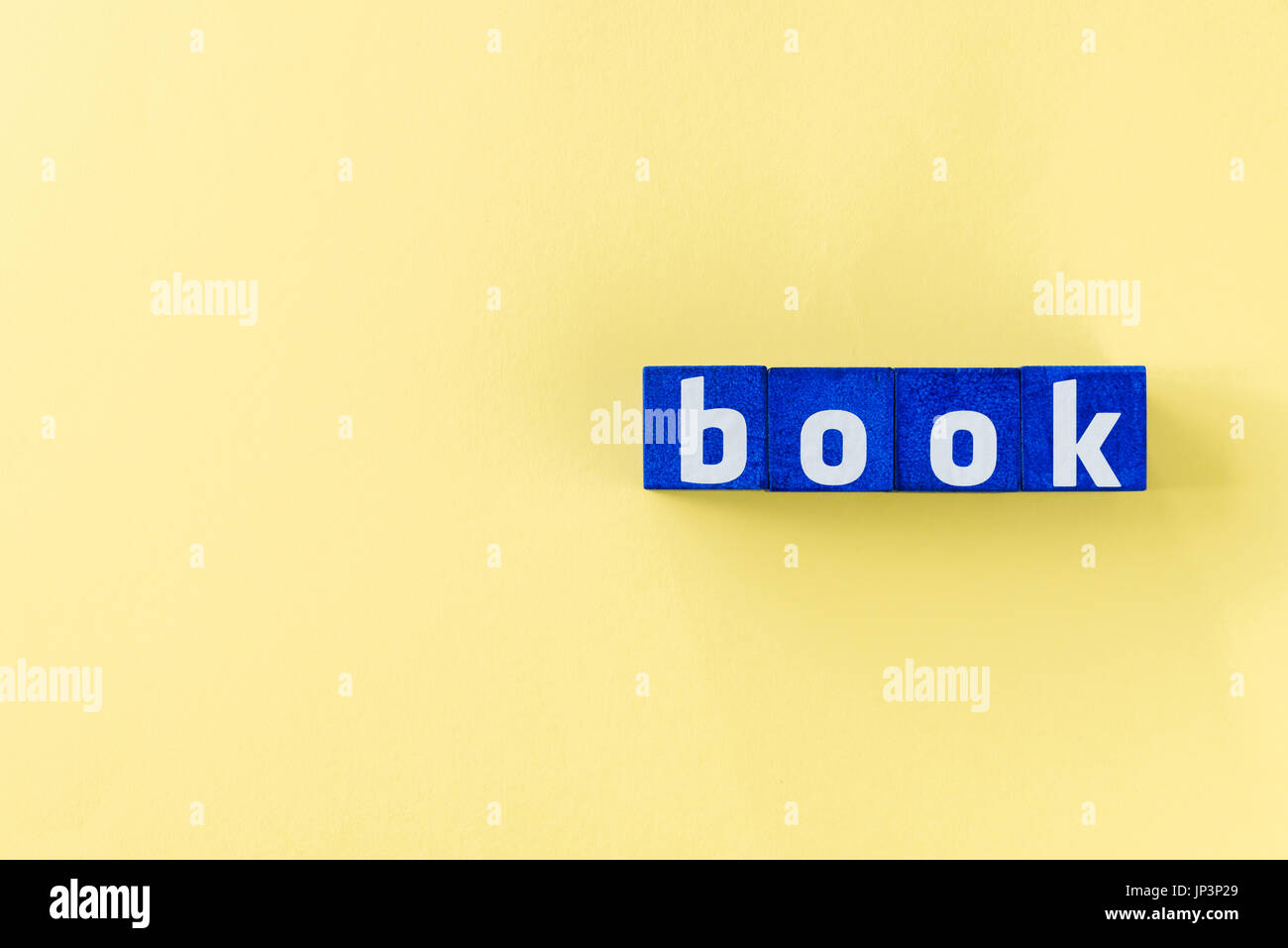 book word made from blue cubes on yellow surface Stock Photo