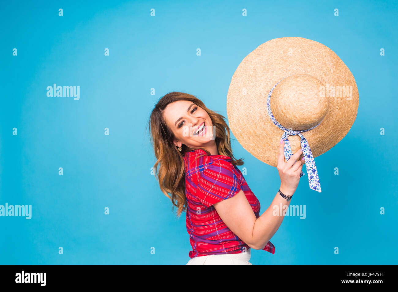 Beautiful young woman wears in summer dress and straw hat is laughing ...