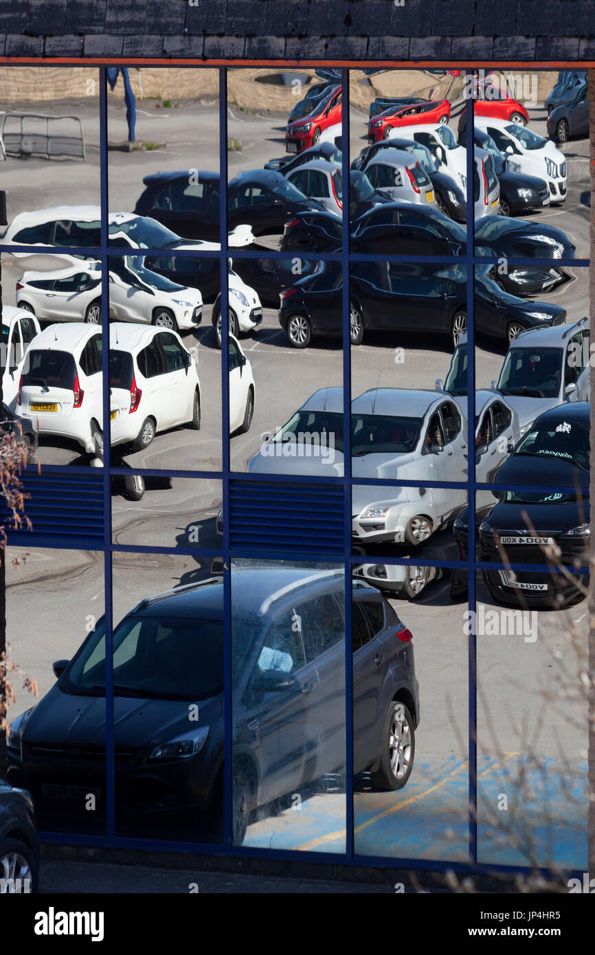 Car park reflected in store window, Halifax, West Yorkshire Stock Photo