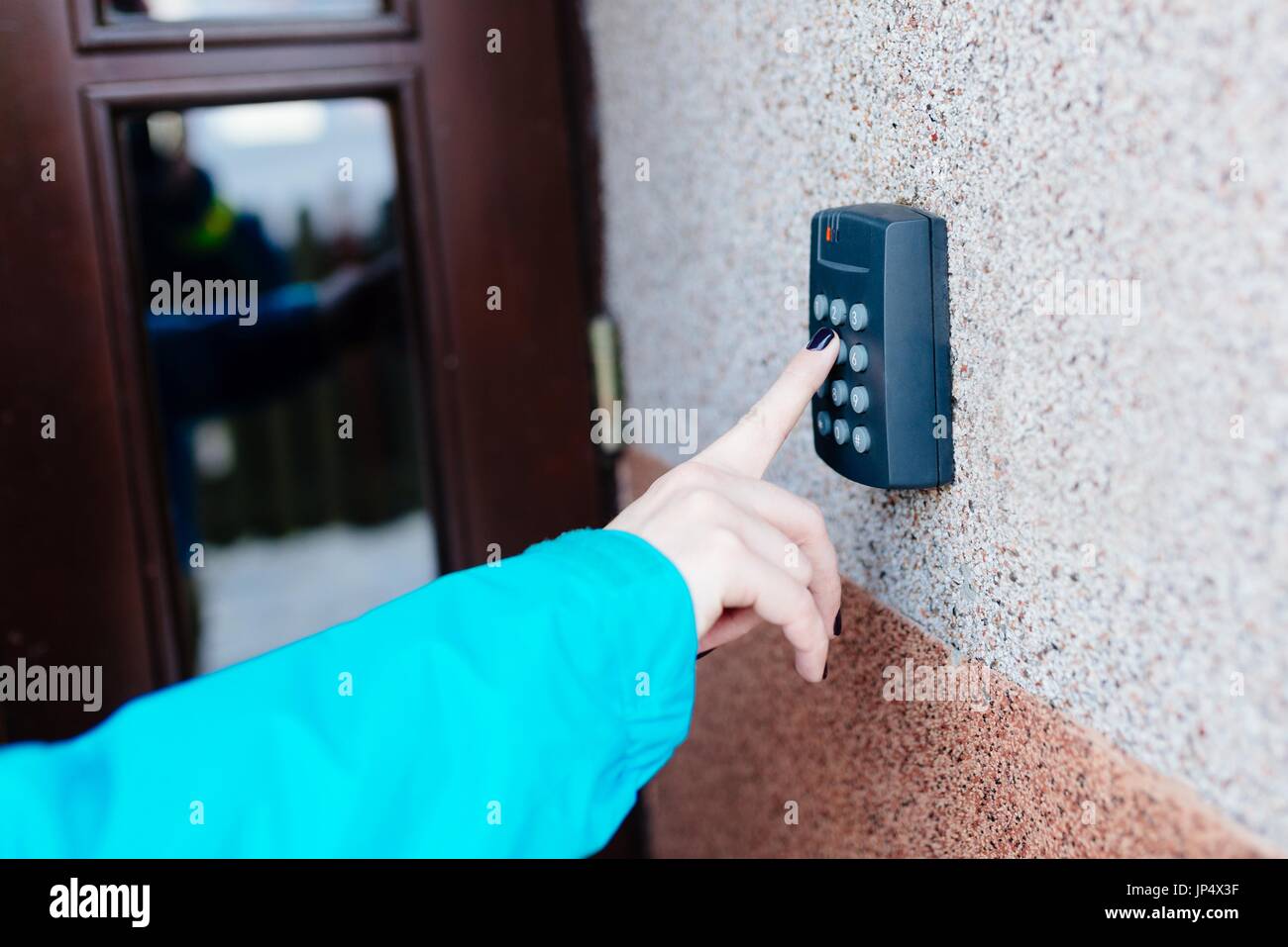 Woman opening house doors with electronic code lock Stock Photo - Alamy