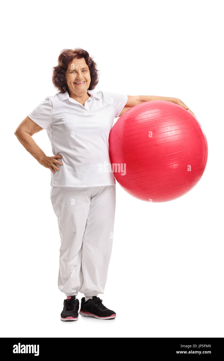 Full length portrait of an elderly woman with a pilates ball isolated on white background Stock Photo