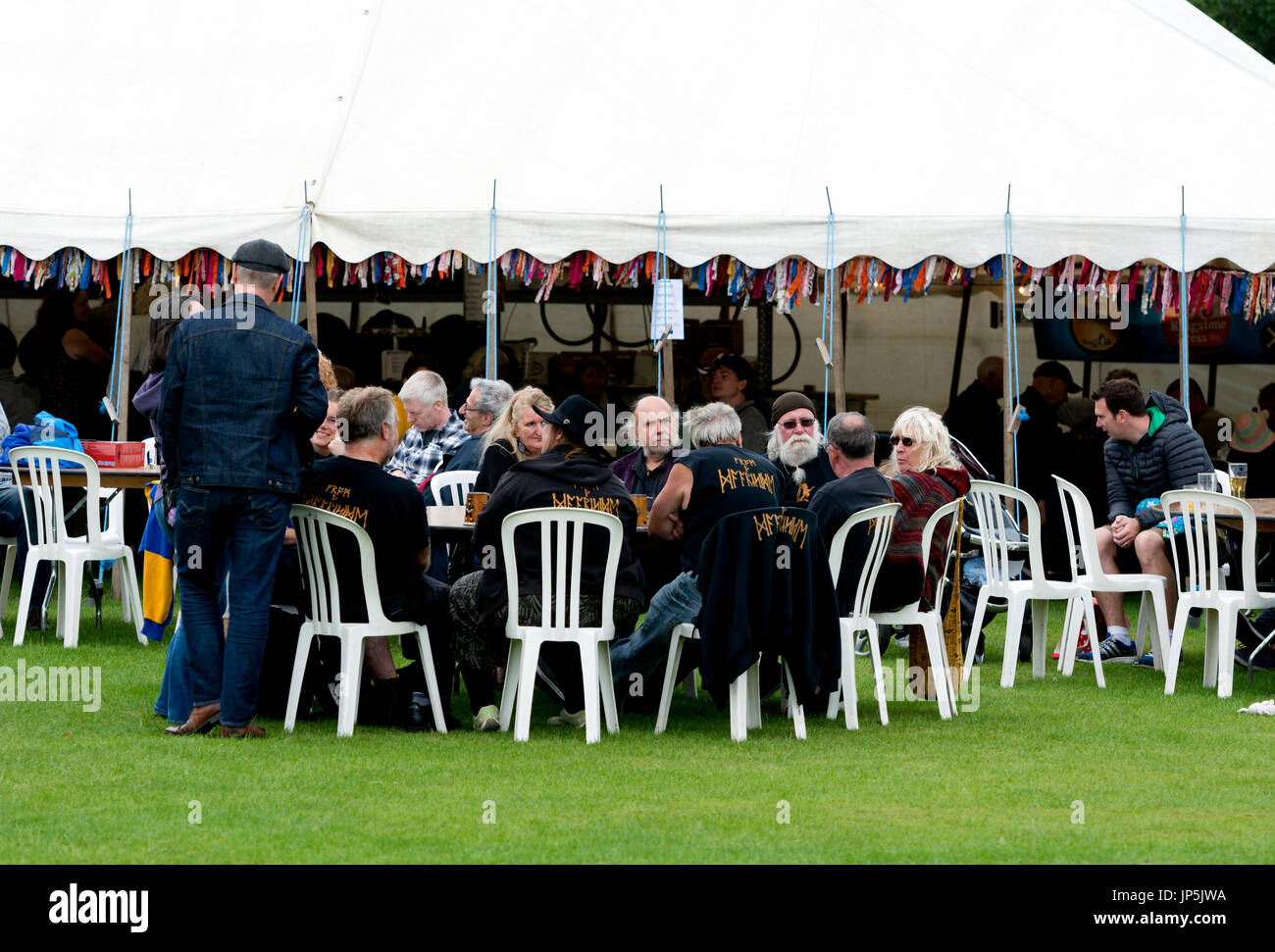 People sat outside the beer tent at Warwick Folk Festival, Warwickshire, UK Stock Photo