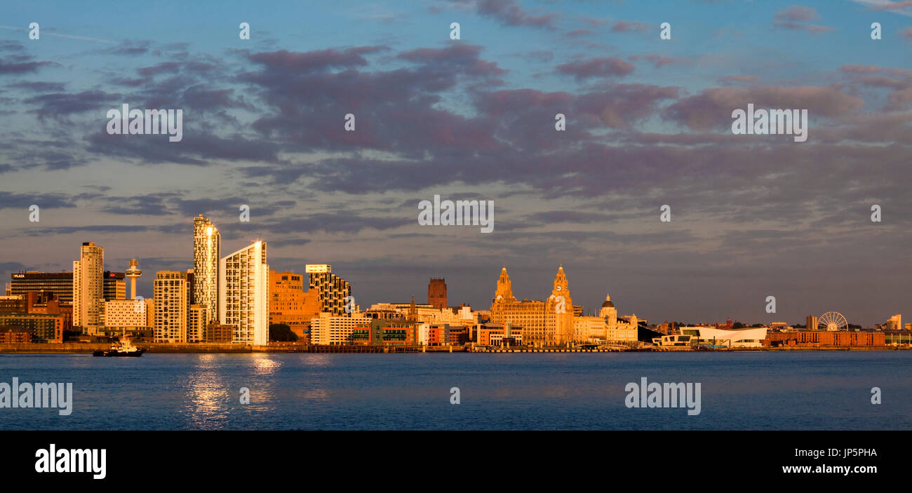Golden glow Liverpool waterfront panorama taken just before dusk across the River Mersey at Seacombe. Stock Photo