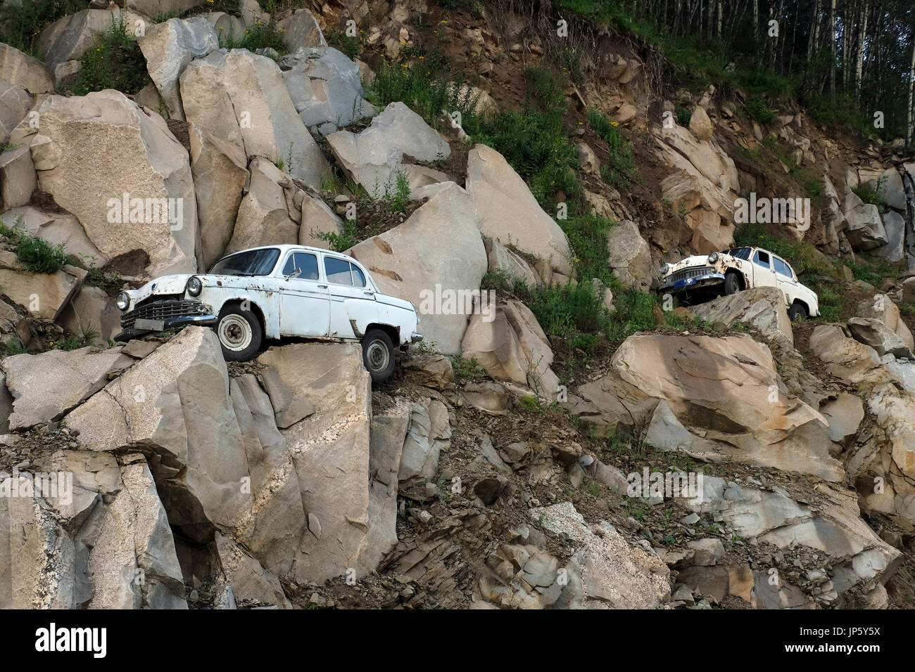 Old Soviet era Moskvitch cars displayed on a hillside along the ...