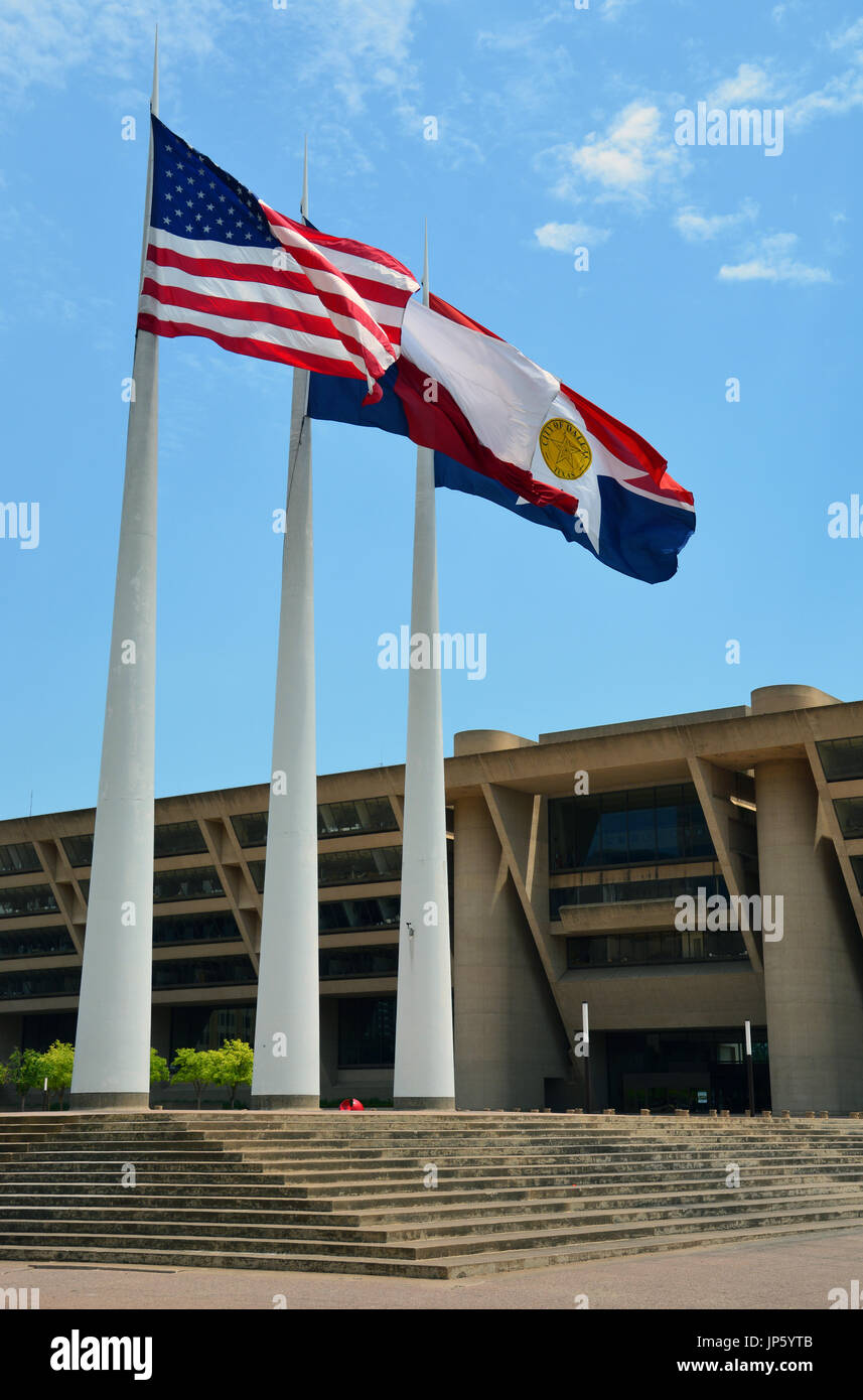 The American, Texas and City of Dallas flags blow in the wind outside of the Dallas City Hall designed by I.M. Pei. Stock Photo