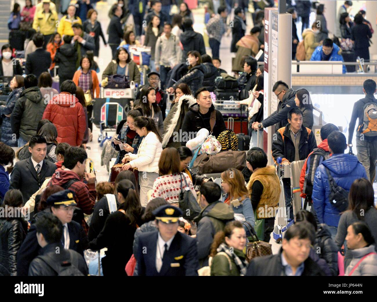 NARITA, Japan - Tourists swarm the arrival lobby at Narita airport east ...