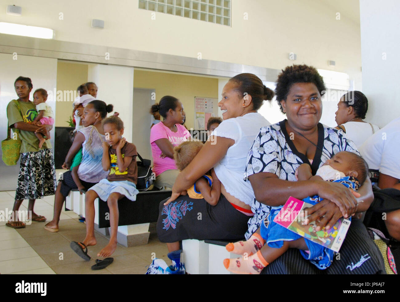 Women and their children await their turn in seeing a doctor at a