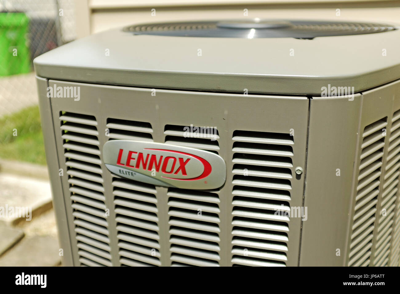 Lennox Elite home air-conditioning unit sits outside in the summer sun. Stock Photo