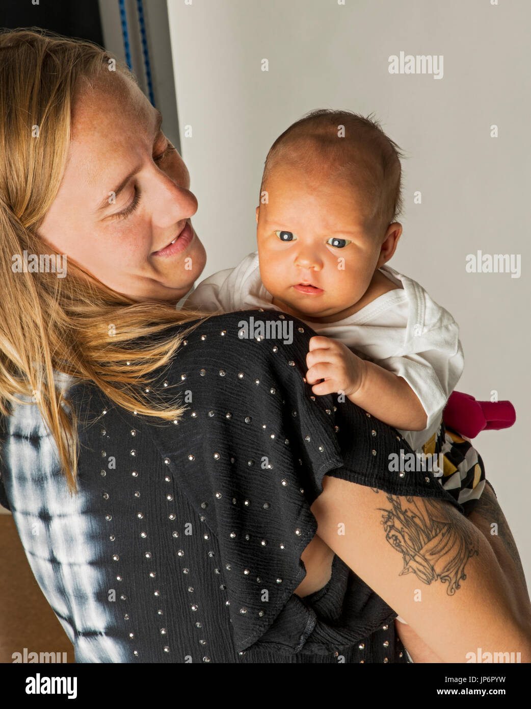 Studio portrait of mother holding 7 week old baby girl Stock Photo