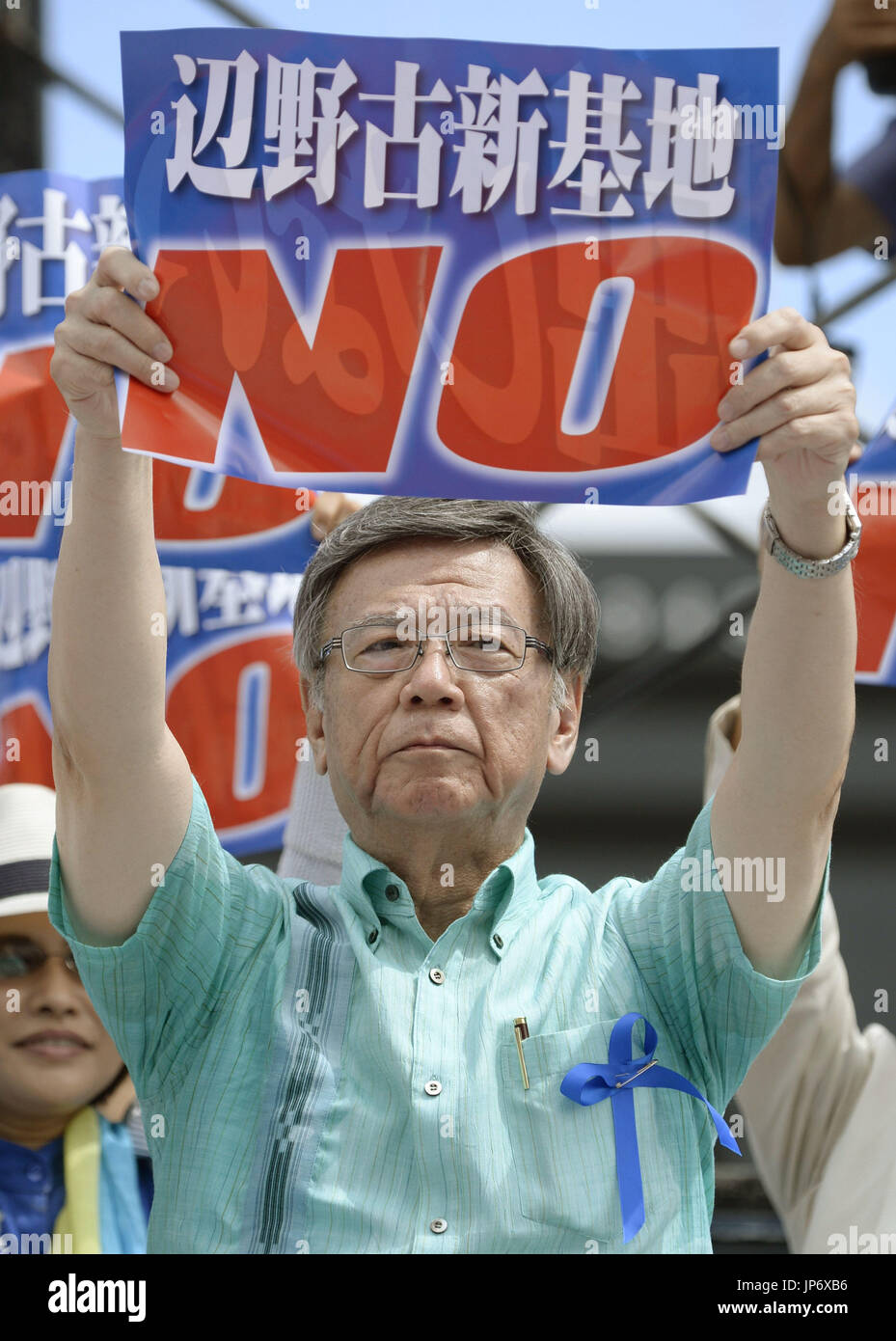 Okinawa Gov. Takeshi Onaga holds a sign reading "No to a new base in