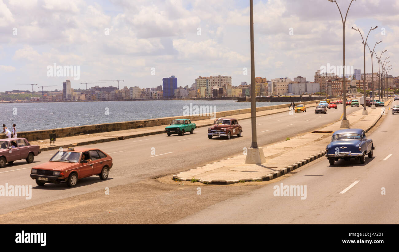 Classic American cars driving on the Malecon seafront boulevard road in Havana, Cuba Stock Photo