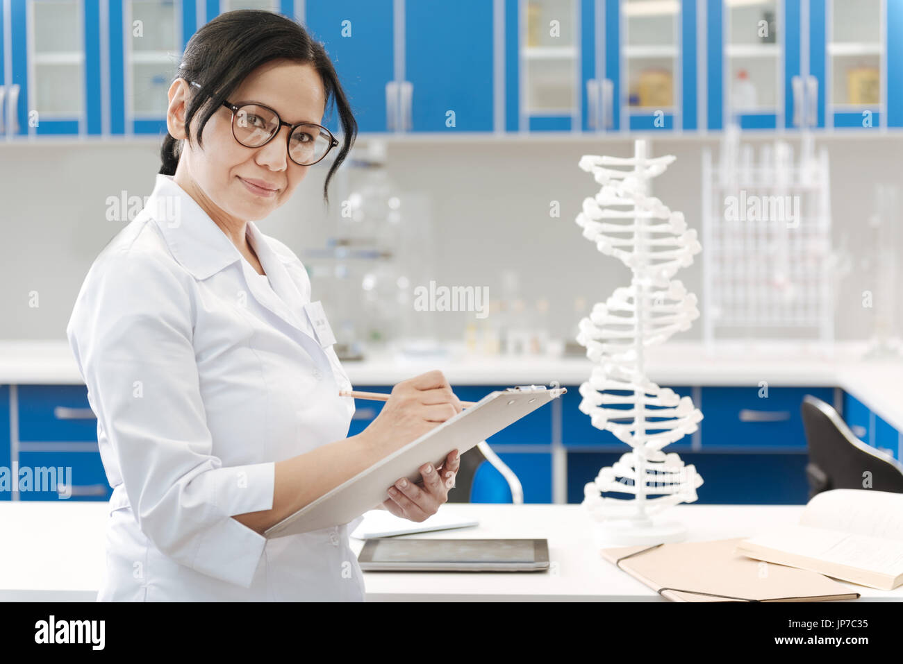 Positive female scientist holding her notes Stock Photo