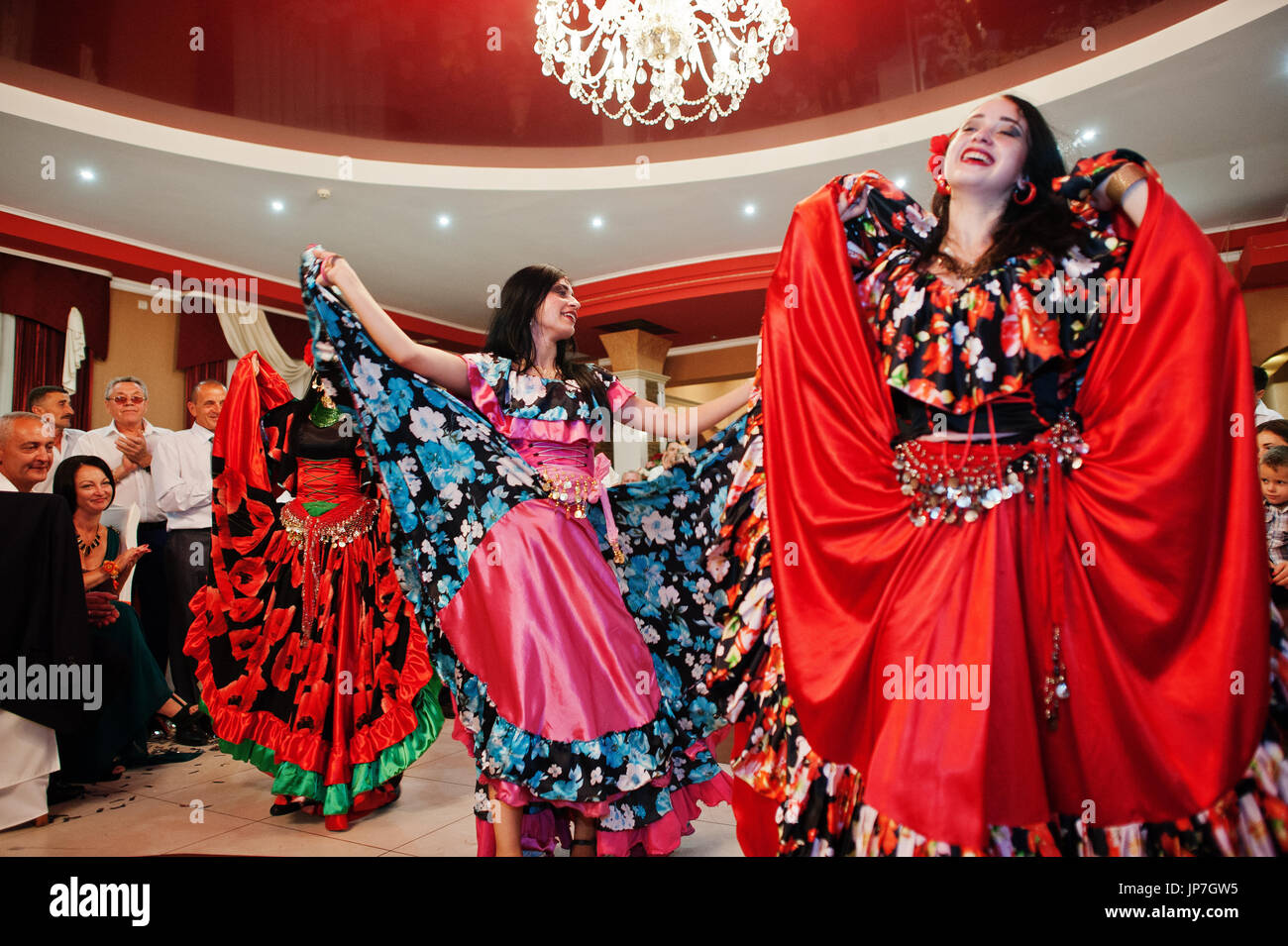 Gypsy dance festival, Woman performing romany dance and folk songs in  national clothing. Beautiful roma gypsy girls dancing in traditional floral  dress at wedding reception in restaurant Stock Photo