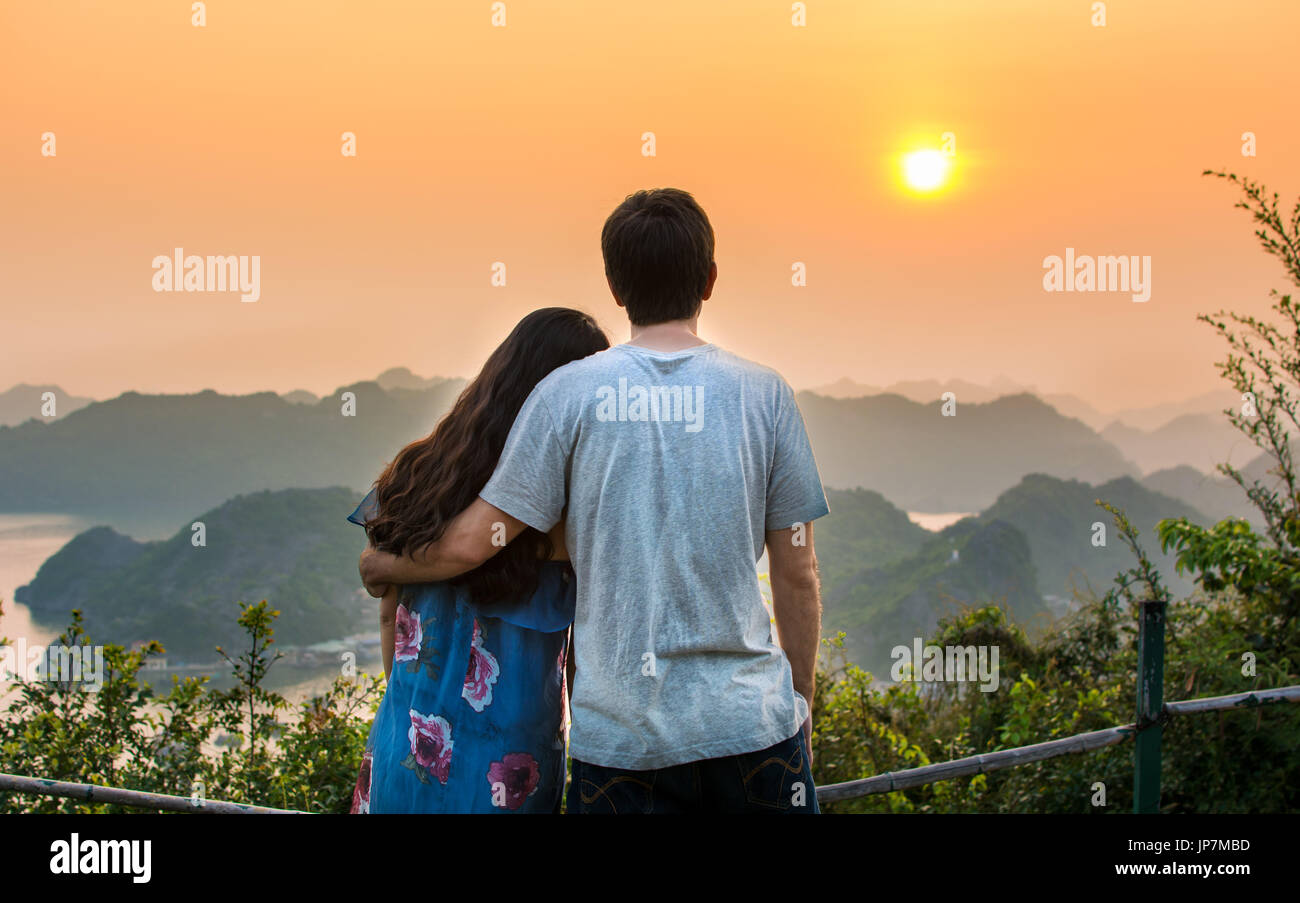 Couple enjoying sunset at romantic seaside viewpoint Stock Photo