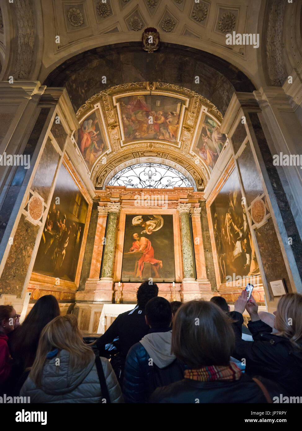 Vertical view of tourists admiring paintings inside Chiesa di San Luigi dei Francesi in Rome. Stock Photo