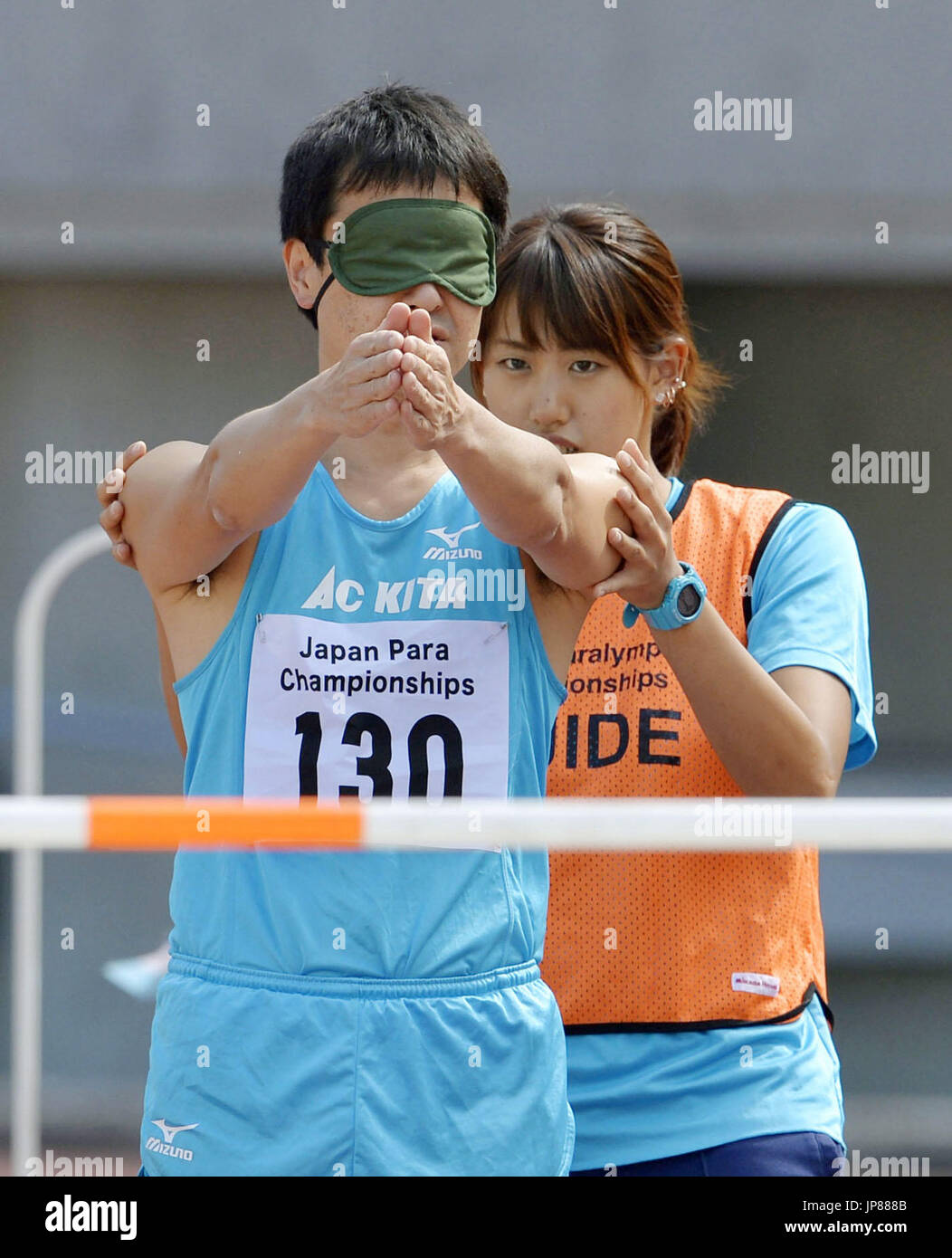 A visually impaired athlete (L) works with his guide to determine the correct running direction