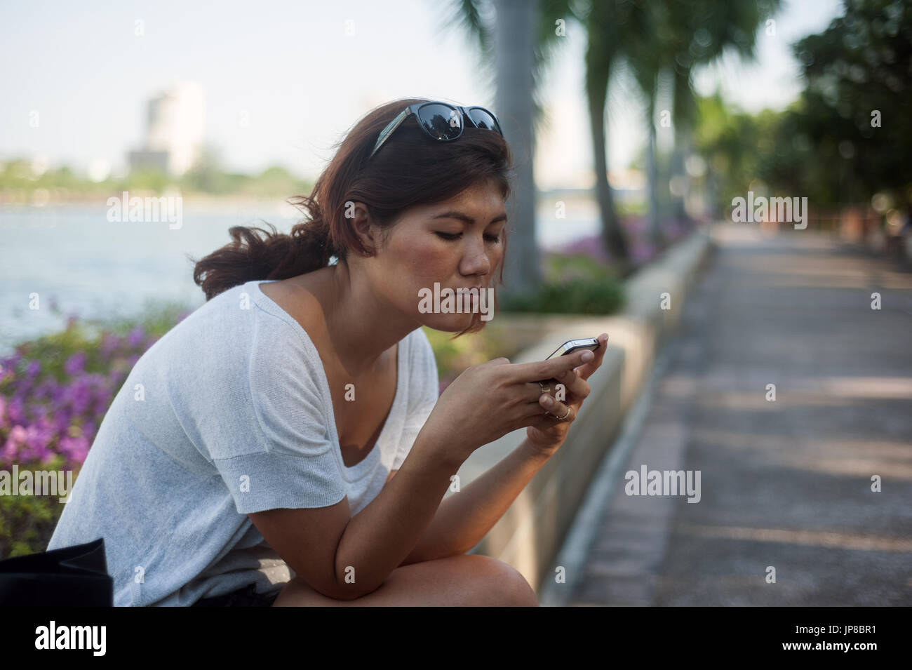 Young Thai woman on smartphone Stock Photo