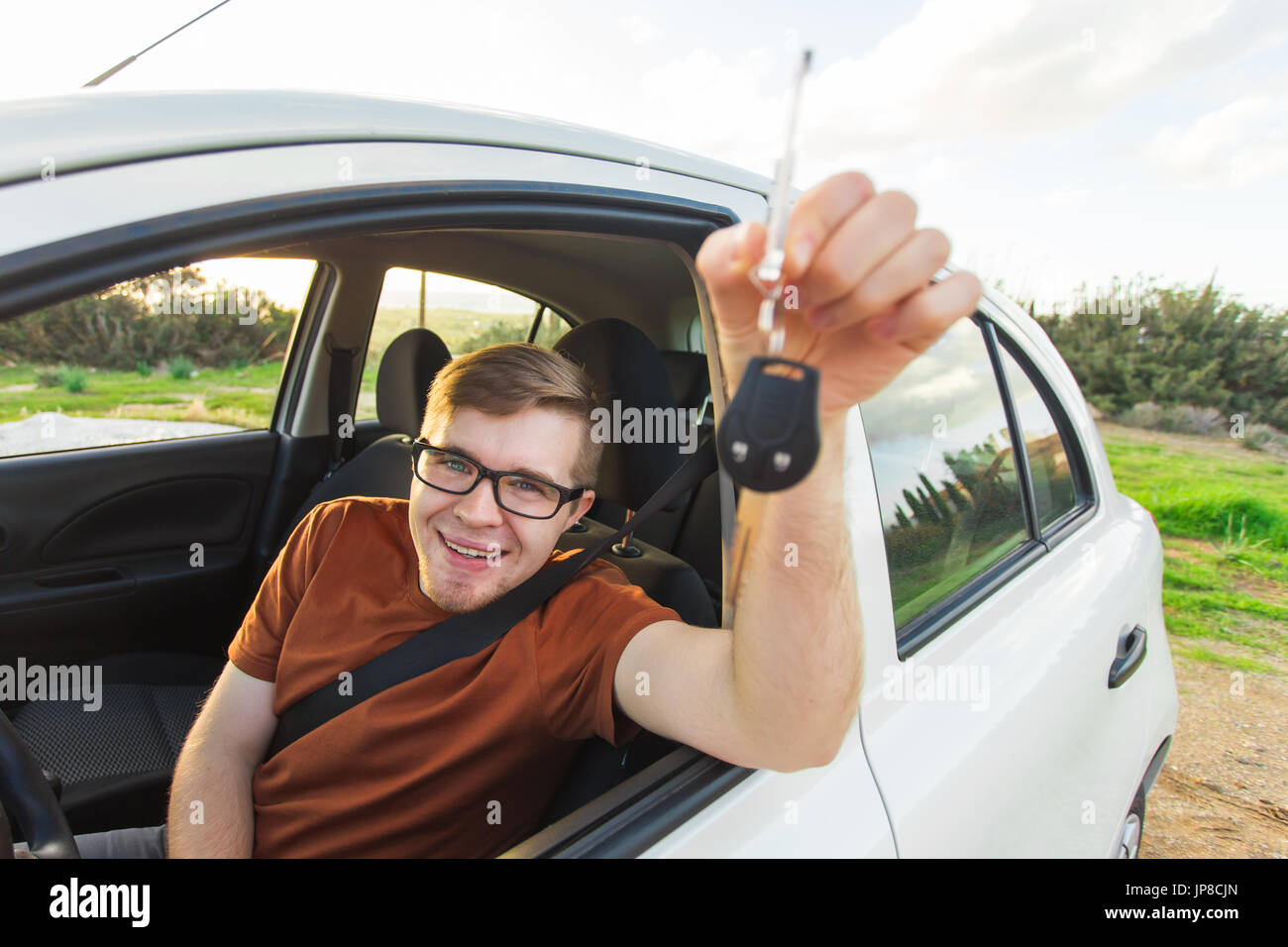 Happy car owner is showing key inside his new car Stock Photo - Alamy