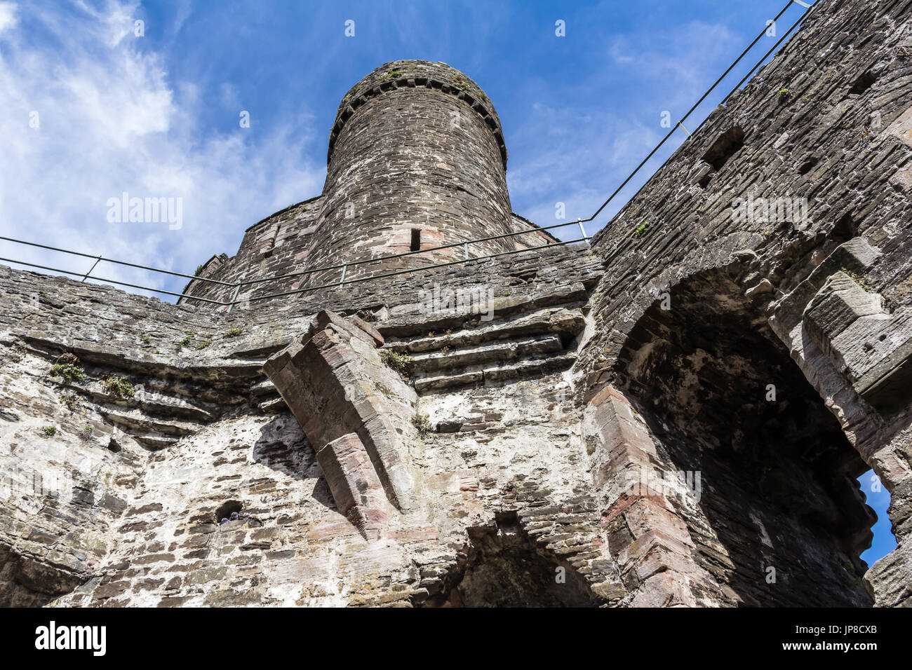 Inside Conwy Castle looking up towards one of the towers, complete with a walkway and safety rails Stock Photo