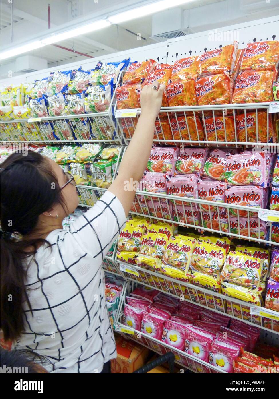A shopper reaches for a packet of instant noodles produced by Acecook ...