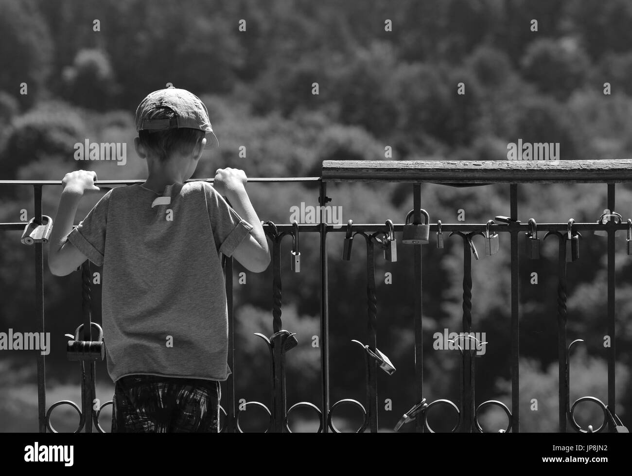 Small kid is watching to horizon. Black and white photo kid is thinking about something. Stock Photo