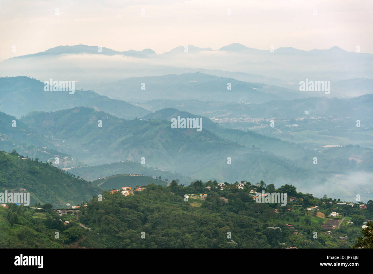 Green rolling hills shrouded in mist near Manizales, Colombia Stock Photo