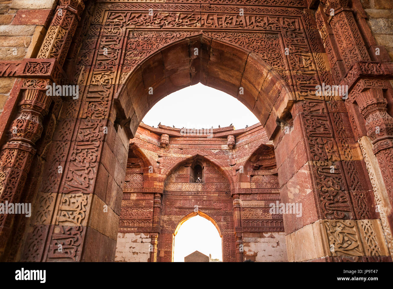 The carved stone arches and walls of the ruins at Qutb Complex in Delhi, India. Stock Photo