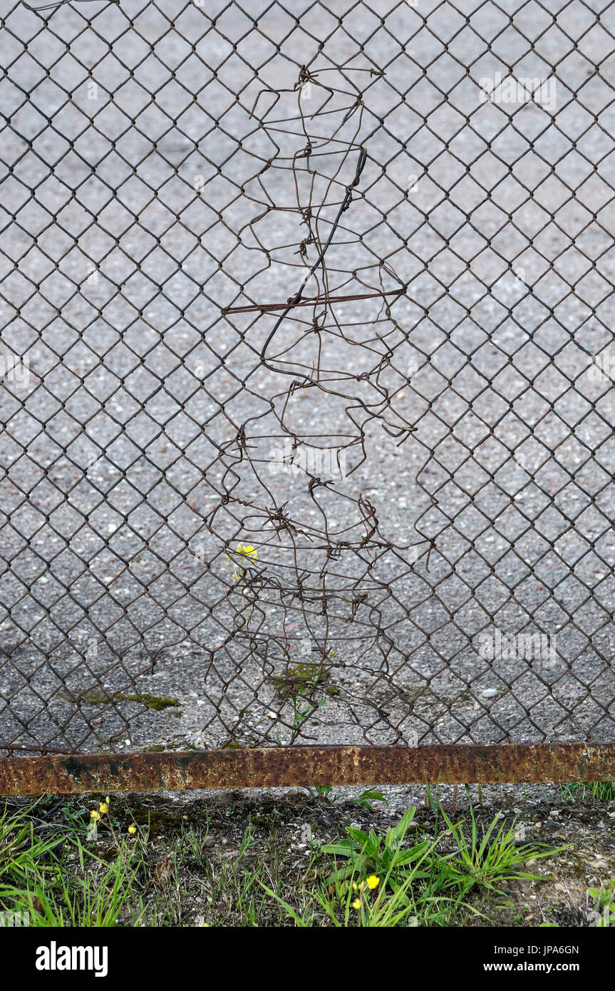 Symbol / Concepts, Wired hole in the iron mesh fence Stock Photo