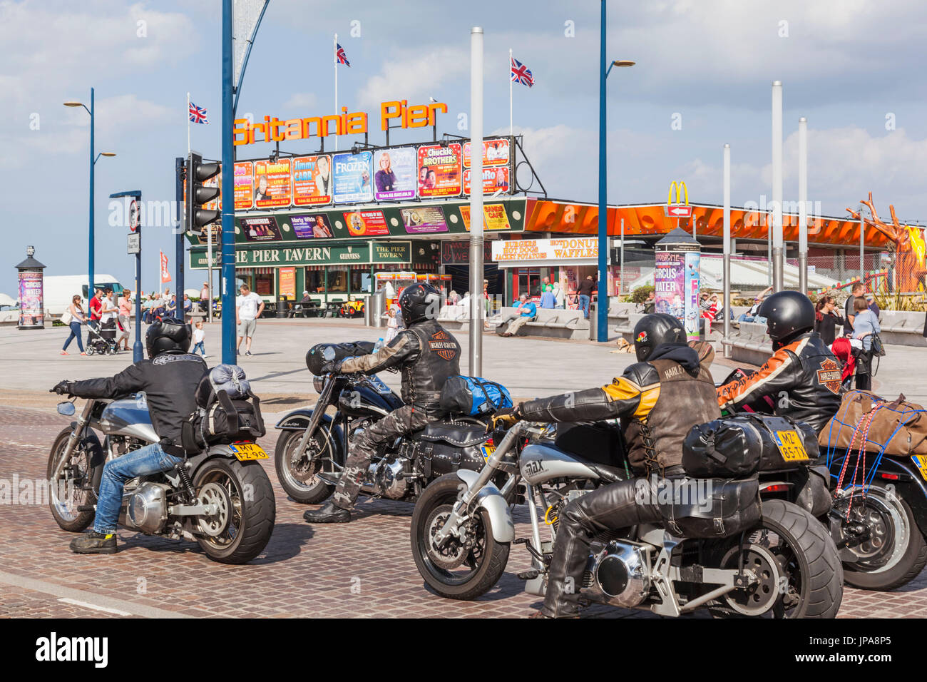 England, Norfolk, Great Yarmouth, Motorcyclists and Great Yarmouth Pier Stock Photo