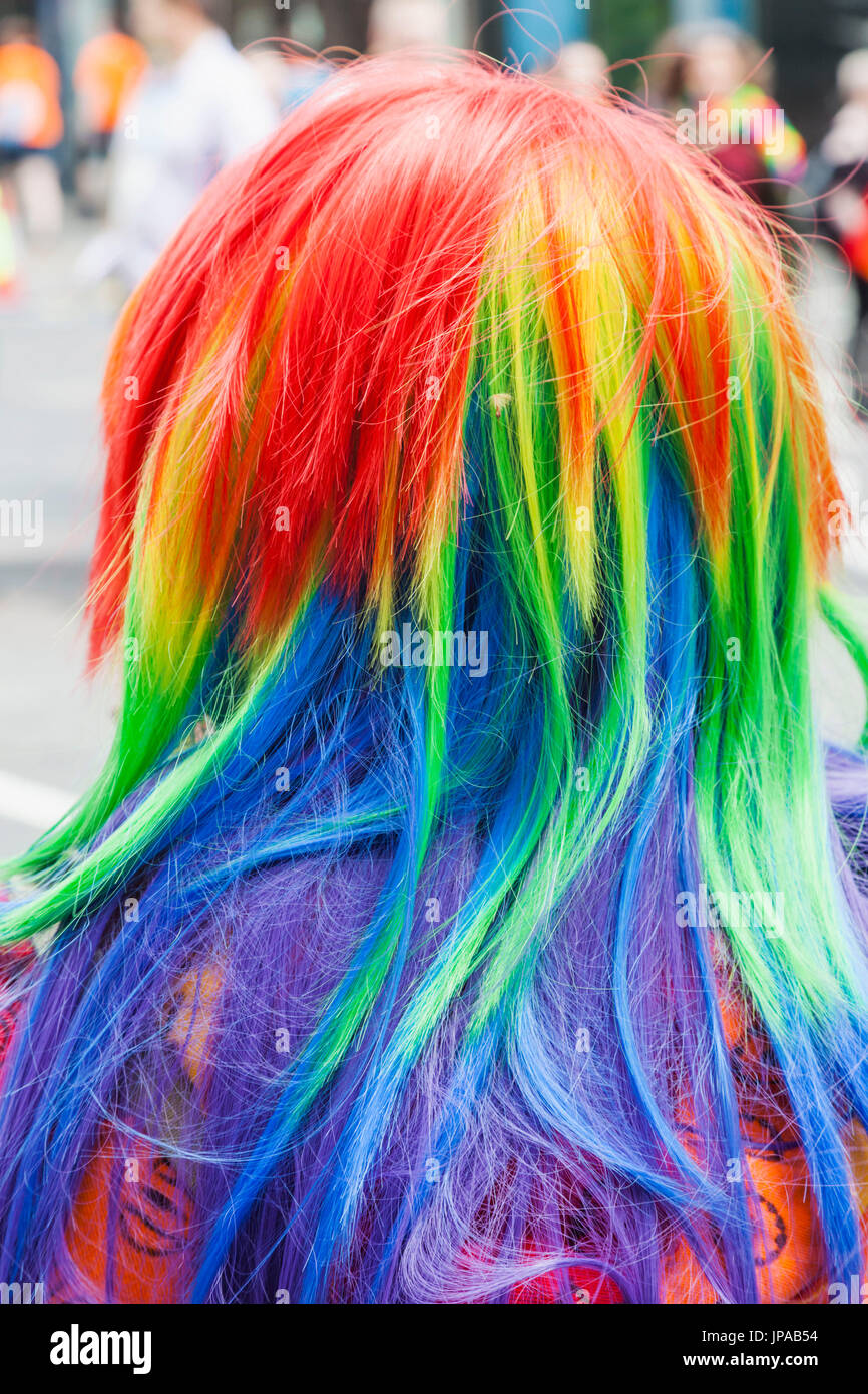 England, London, Annual Pride Parade Participant Wearing LGBT Rainbow Coloured Wig Stock Photo