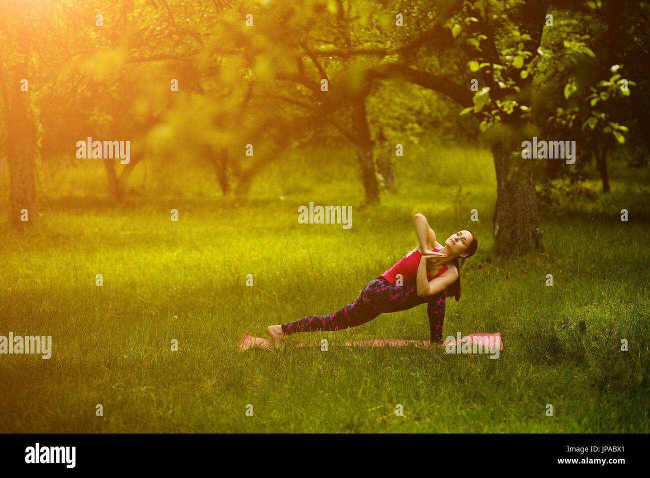 Young female practicing extended side angle pose with twist. Stock Photo