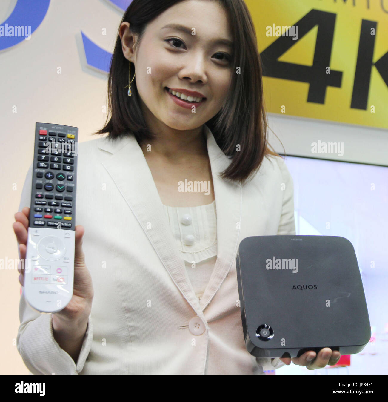 A woman holds up Sharp Corp.'s Aquos Cocoro Vision Player equipped with artificial intelligence during a presentation in Tokyo on April 21, 2016. The device can recommend drama series and videos that viewers might like when connected to the company's Aquos brand TV sets. The device will be put on the market on June 10 with a price tag of around 21,600 yen ($196.80). (Kyodo) ==Kyodo Stock Photo
