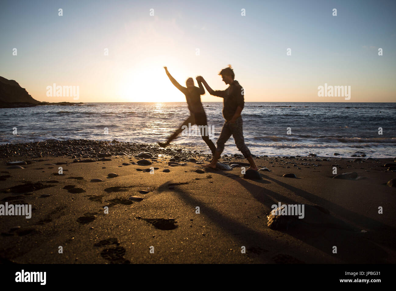 Couple on the beach in back light Stock Photo