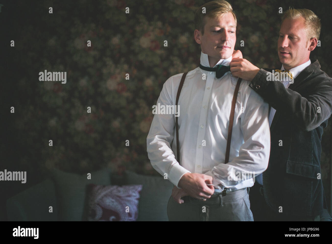 Bridegroom and groomsman, bow tie, tie up, help, nervousness, half portrait Stock Photo