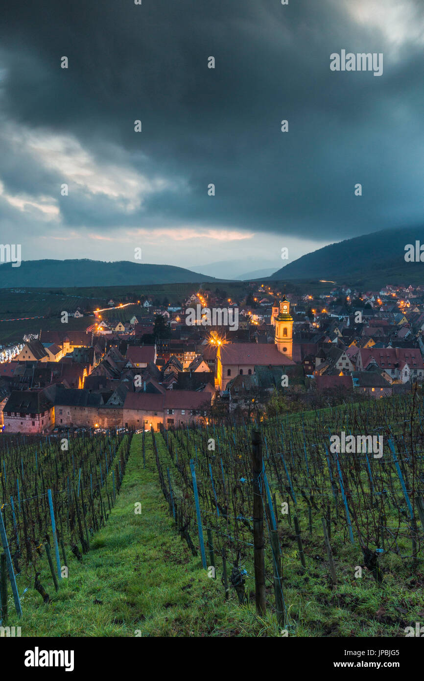 Clouds and lights on the old town of Riquewihr framed by green vineyards  Haut-Rhin department Grand Est Alsace France Europe Stock Photo
