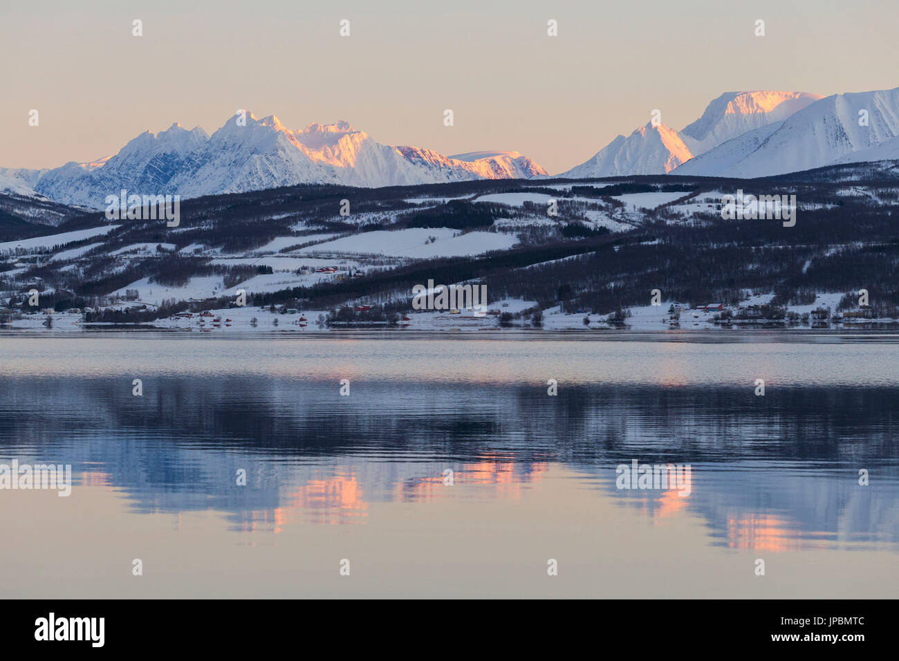Lyngen Alps are reflected in Balsfjorden during a artic sunrise. Markenes, Balsfjorden, Lyngen Alps, Troms, Norway, Lapland, Europe. Stock Photo