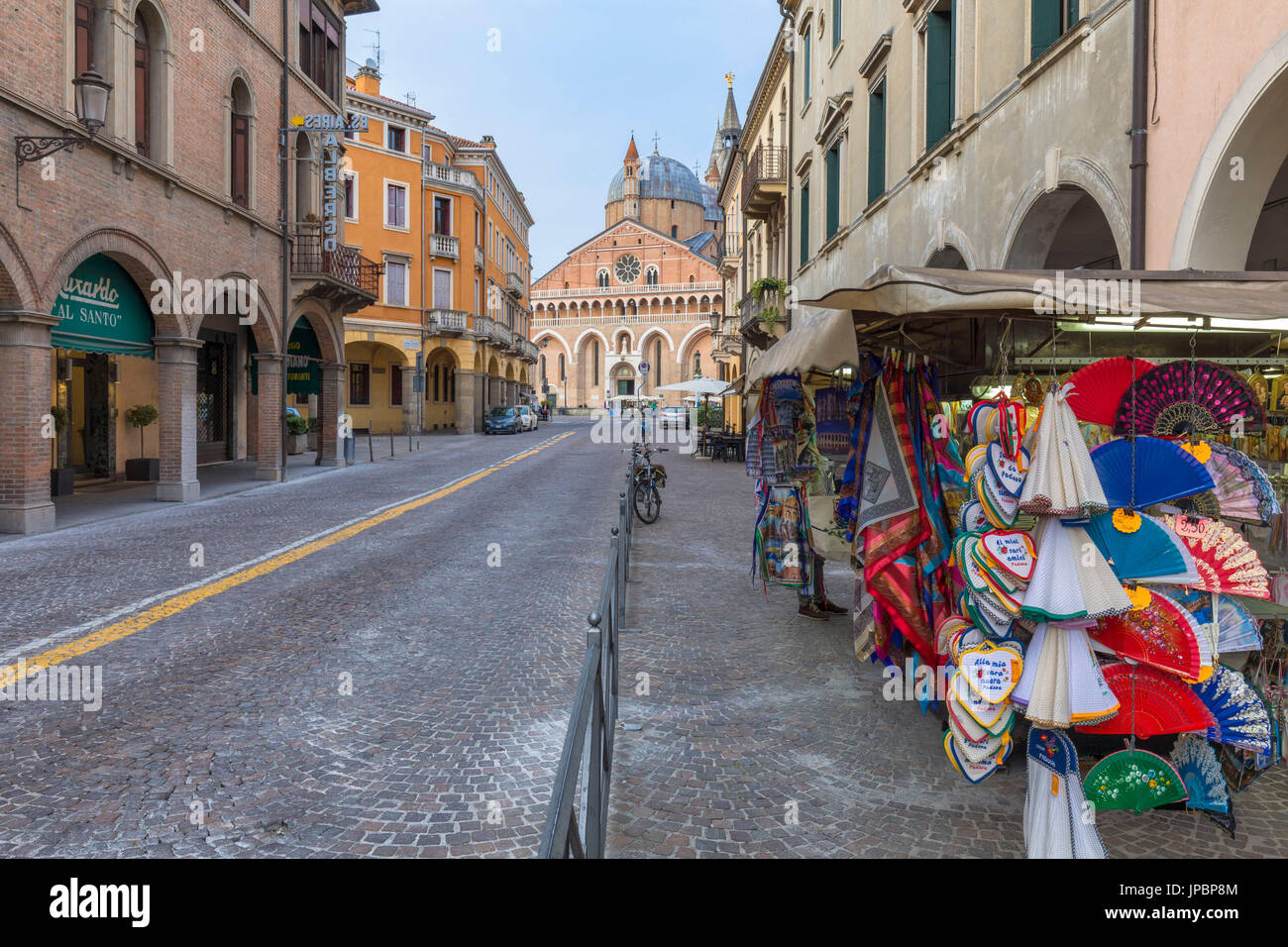 Central street in Padua, Italy looking to the Basilica of St Anthony with brightly colored garments for sale on the side walk in the foreground, veneto, italy, europe Stock Photo