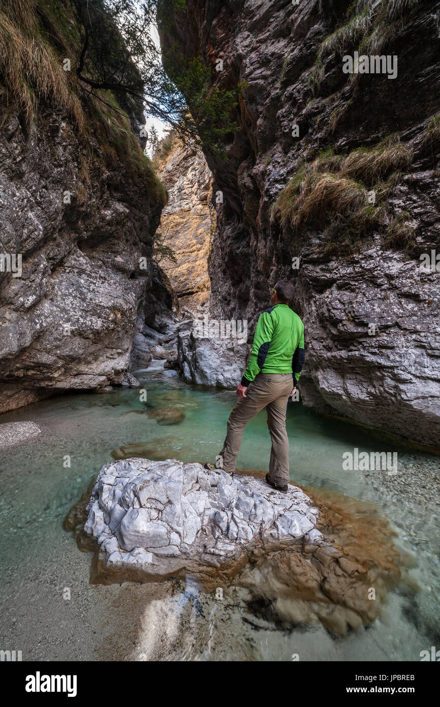 Hiker observes the gorge of the Val Soffia, above the waterfall. Monti del Sole, Belluno Dolomites National Park Stock Photo