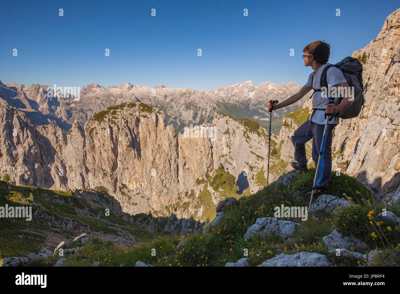 Hikers at Passo del Ciodo admire the panorama to the steep walls of the Third and Fourth Pala. In the background the plateau of the Pale di San Martino. Dolomites, Pale di San Lucano, Agordino, Belluno, Veneto, Italy Stock Photo