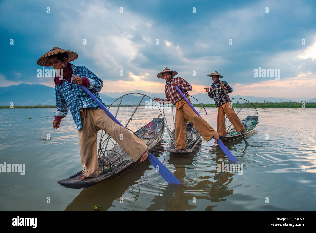 Inle lake, Nyaungshwe township, Taunggyi district, Myanmar (Burma). Thee local fishermen rowing in row. Stock Photo