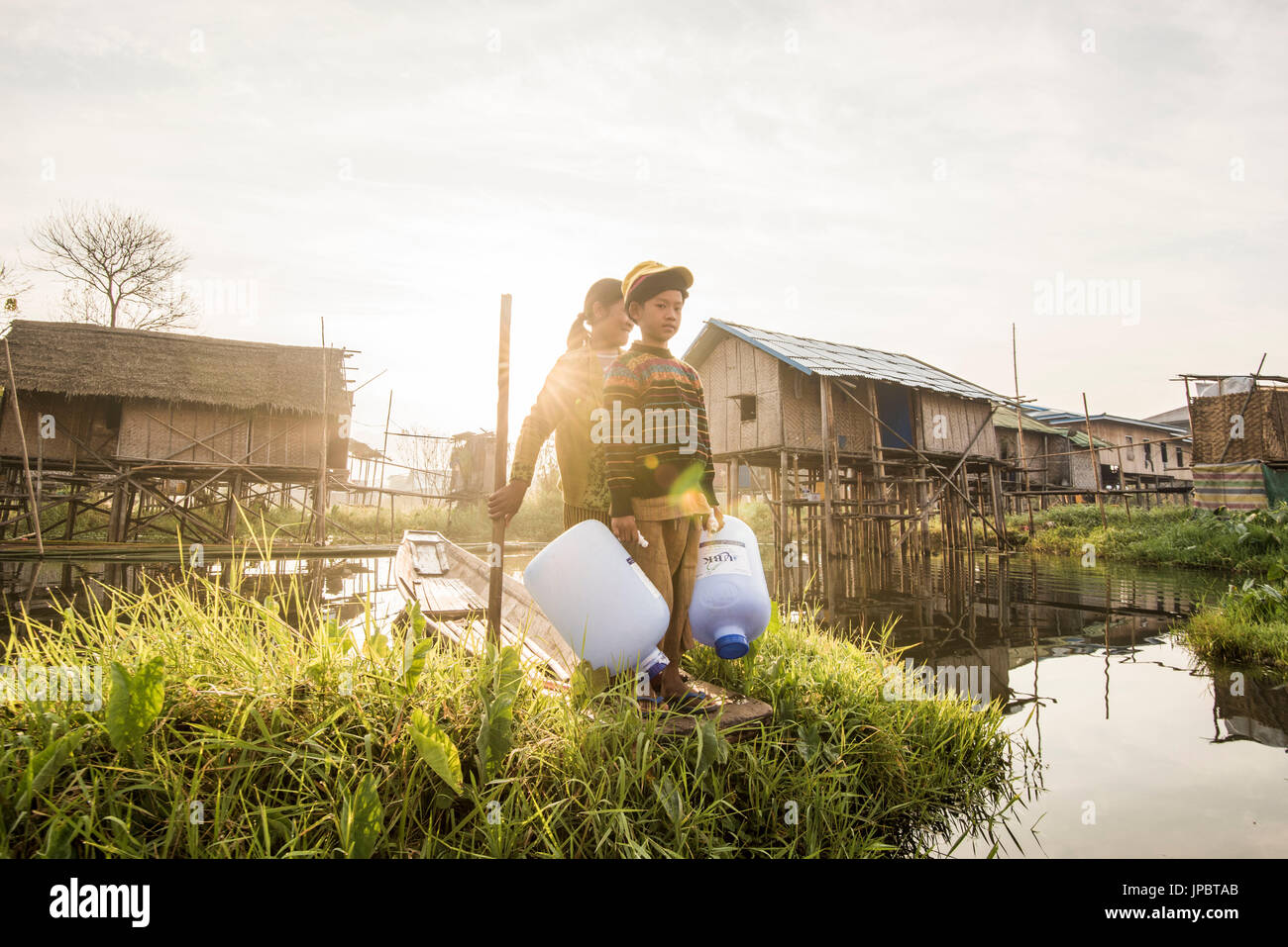 Inle lake, Nyaungshwe township, Taunggyi district, Myanmar (Burma). Girl and a child on a boat between the floating houses on the lake. Stock Photo