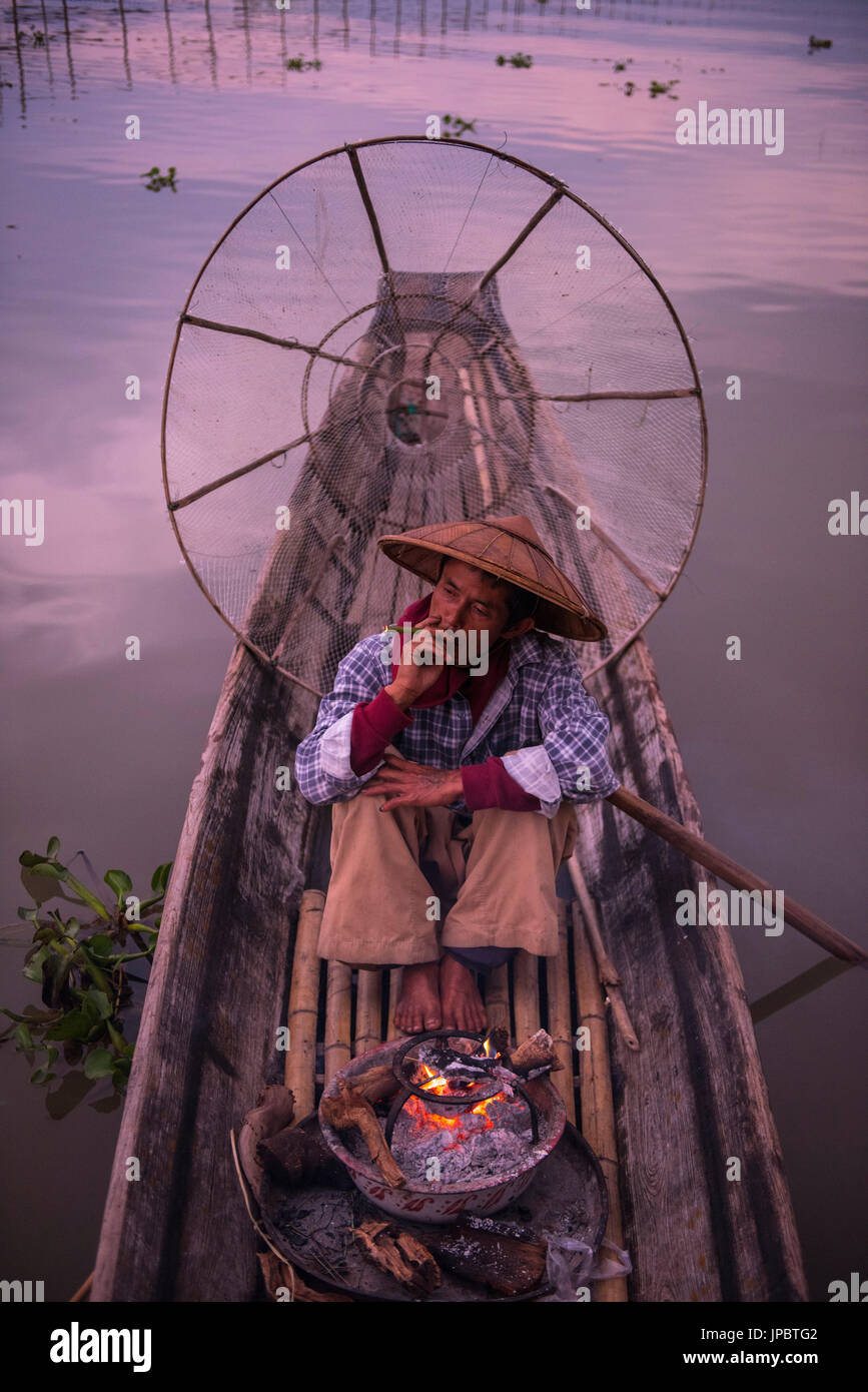 Inle lake, Nyaungshwe township, Taunggyi district, Myanmar (Burma). Local fisherman before dawn with fireplace on the boat. Stock Photo