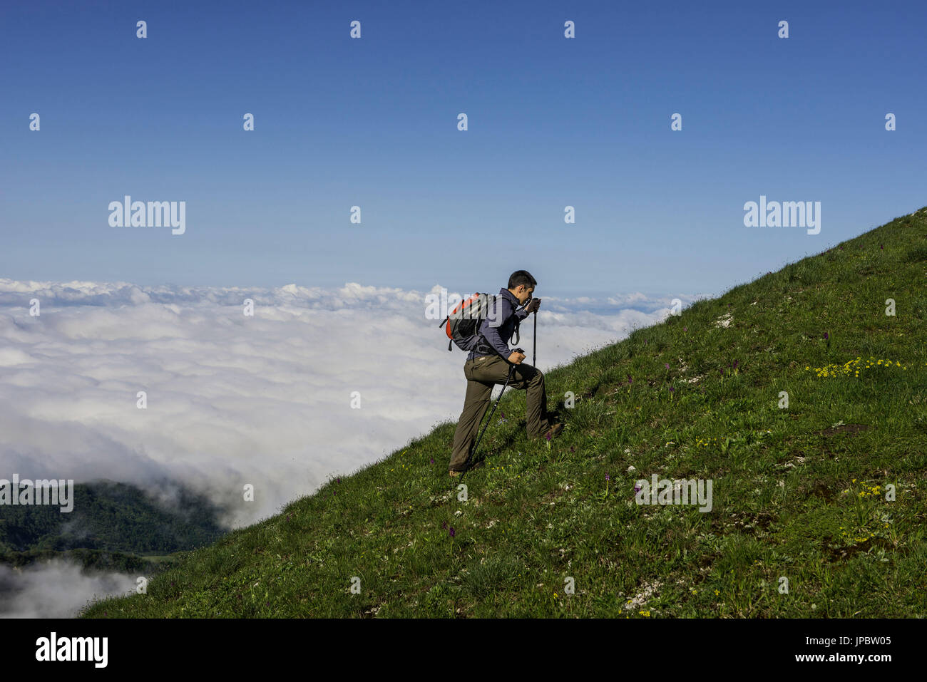 Hiker over the clouds on Apennines mountain range, Umbria, Italy Stock Photo