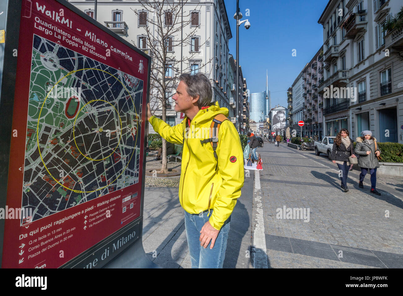 A tourist looks at the map for the walking routes in town Milan Lombardy Italy Europe Stock Photo