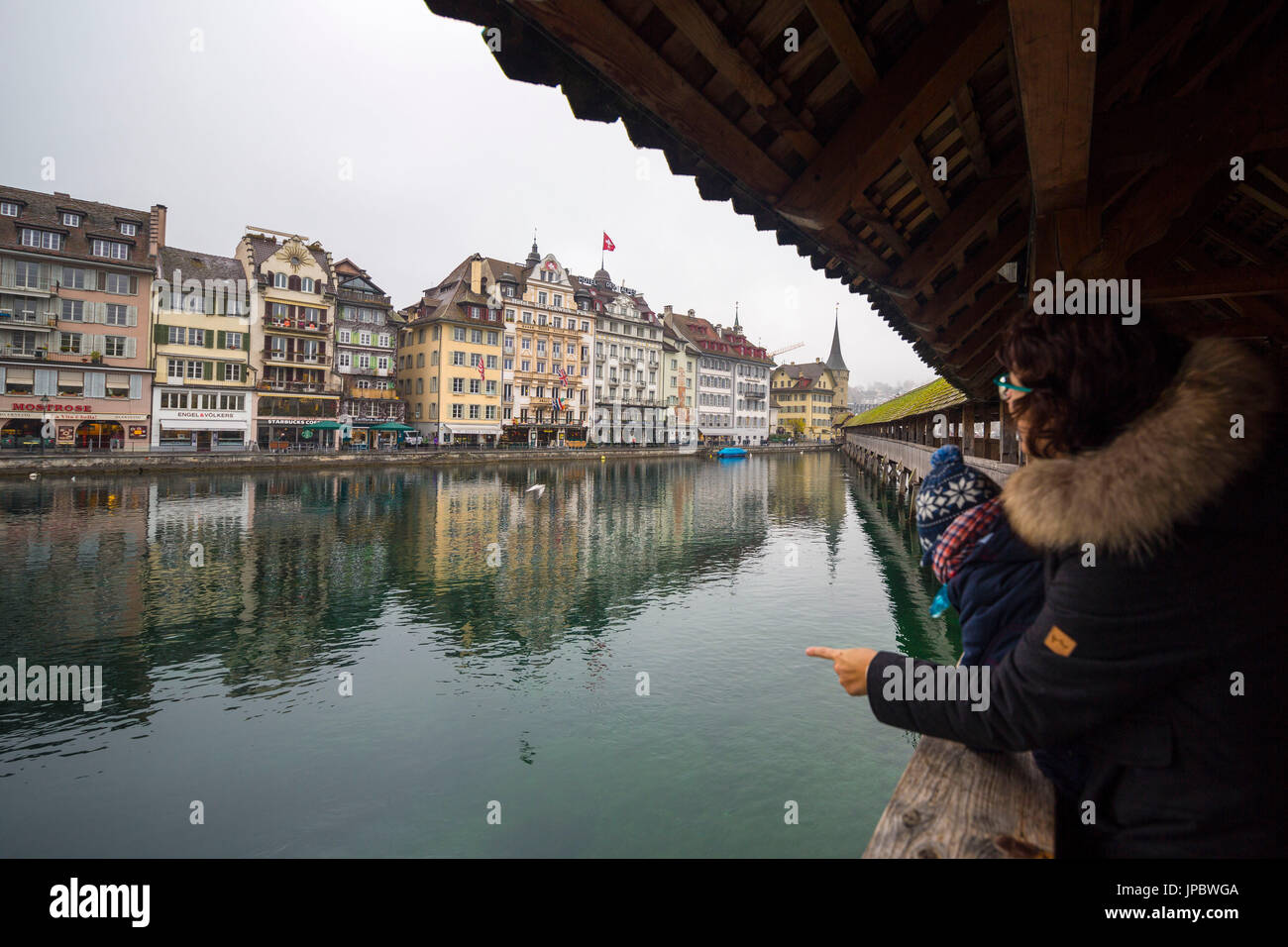 Tourists on Chapel Bridge admire the typical buildings of the old town on river Reuss Rathausquai Lucerne Switzerland Europe Stock Photo