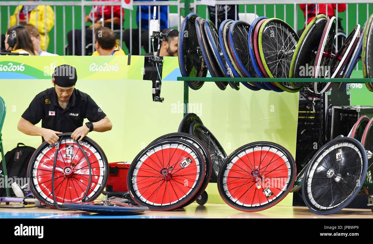 Japan's wheelchair rugby team staff repairs wheels on the courtside at