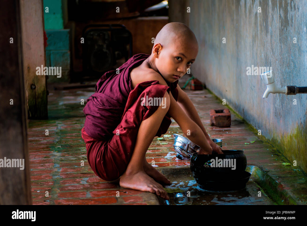 Mahagandayon Monastery, Amarapura, Myanmar, South East Asia. young buddhist novices. who conducts his daily activities inside the monastery Mahagandayon. Stock Photo