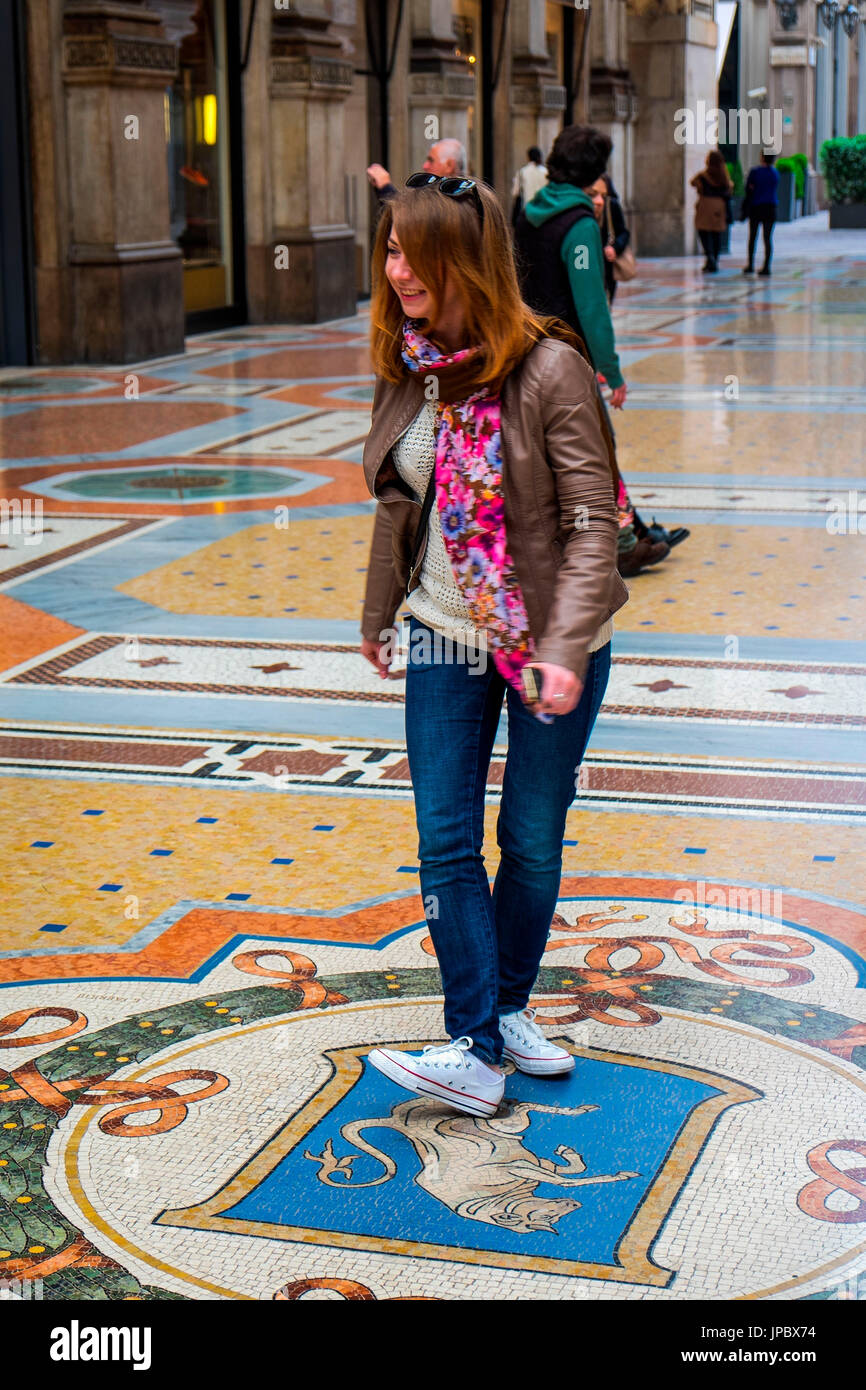 Galleria Vittorio Emanuele, Milan, Lombardy, Italy, Europe. A enjoyed tourist on the good luck symbol at Milan. Stock Photo