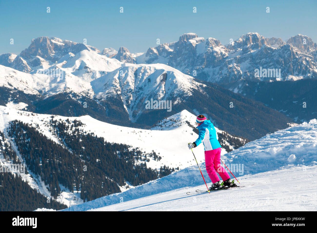 Skier on ski slopes of Pass Brocon framed by the Pale Di San Martino in the background Dolomites Belluno Trentino Italy Europe Stock Photo